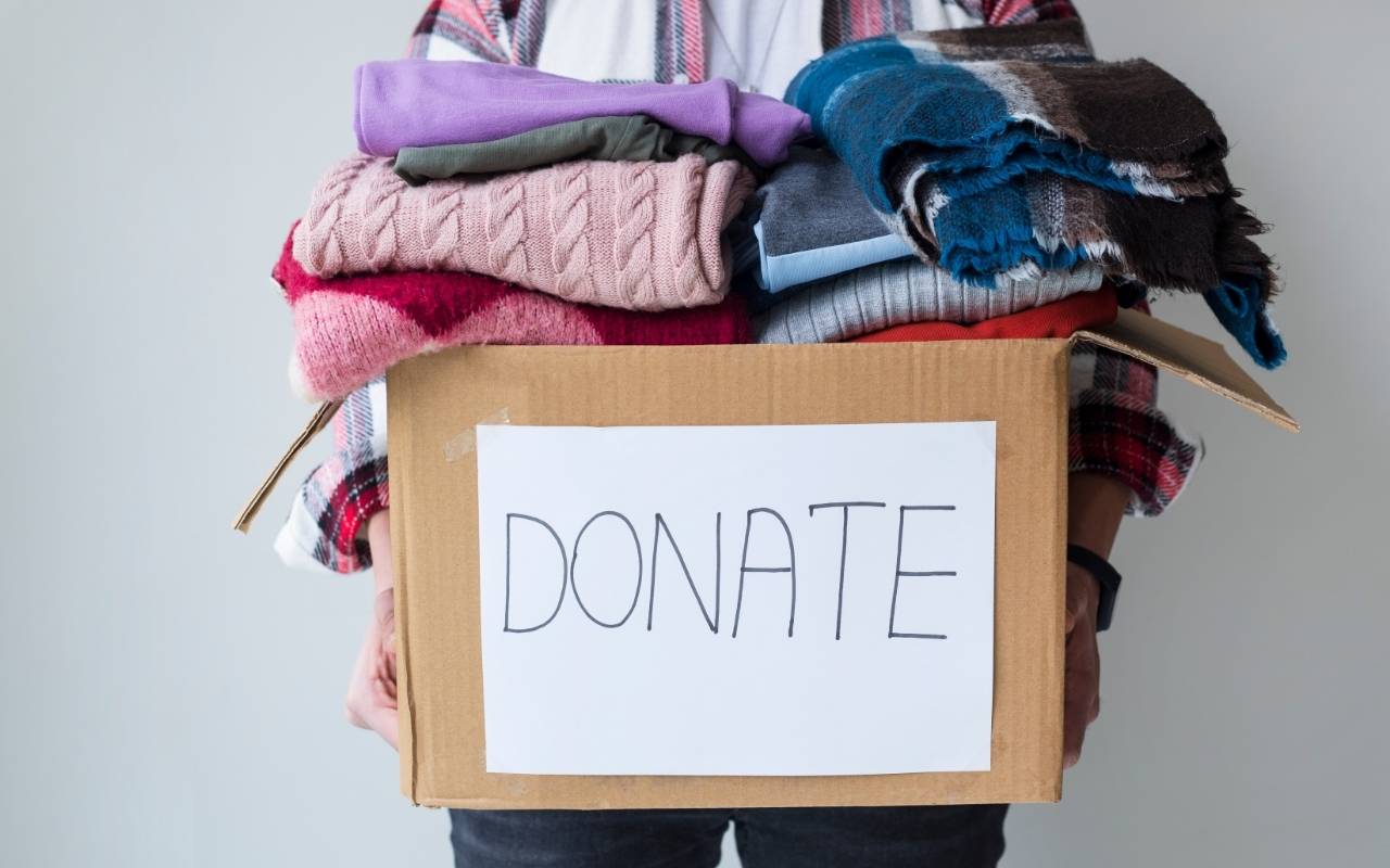 Person carrying donation boxes from a San Mateo home before moving